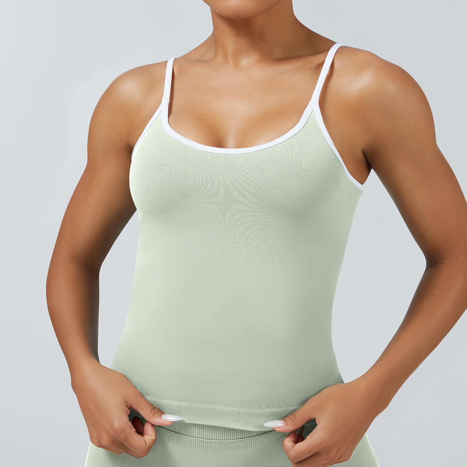 Light green seamless camisole tank top with removable chest pads and white binding, perfect for workout and athleisure wear